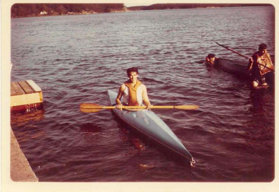 Old photograph of Mick Gue in a canoe during his time in the Army