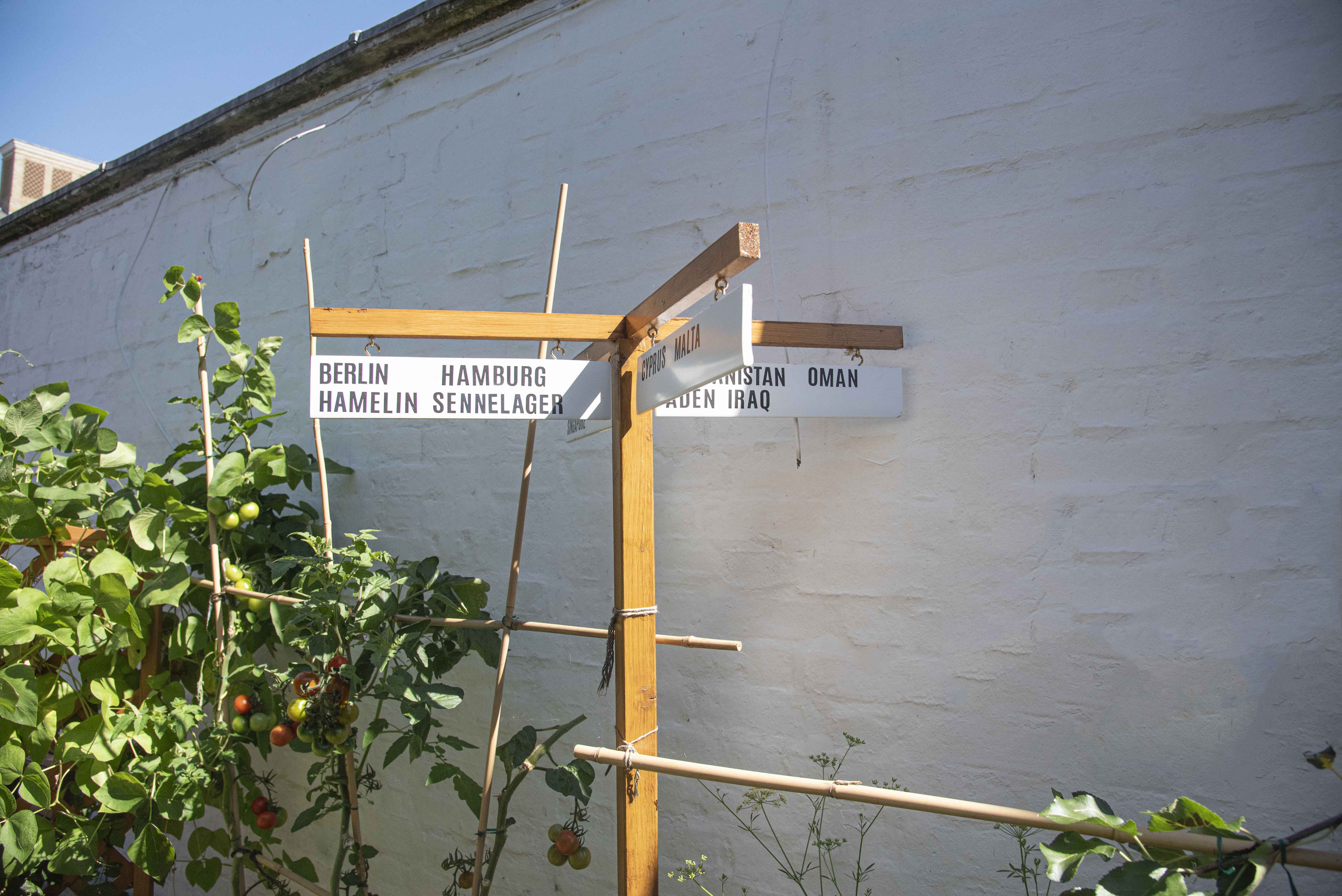A sign listing different destinations in Archie's garden