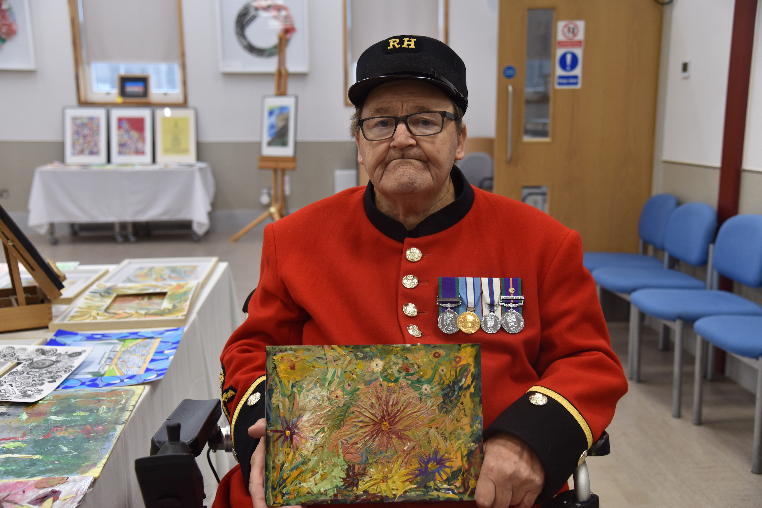 Chelsea Pensioner David Hinds holds his painting of a flower