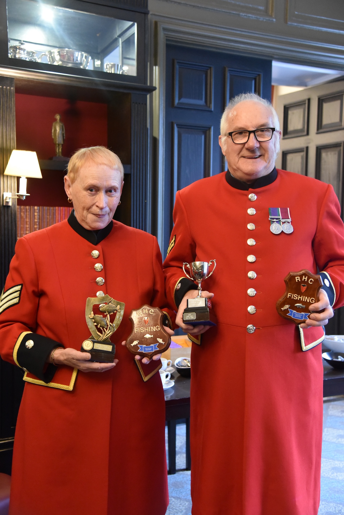 Chelsea Pensioners Ann Phipps (left) and David Lines (right) holding their fishing club award