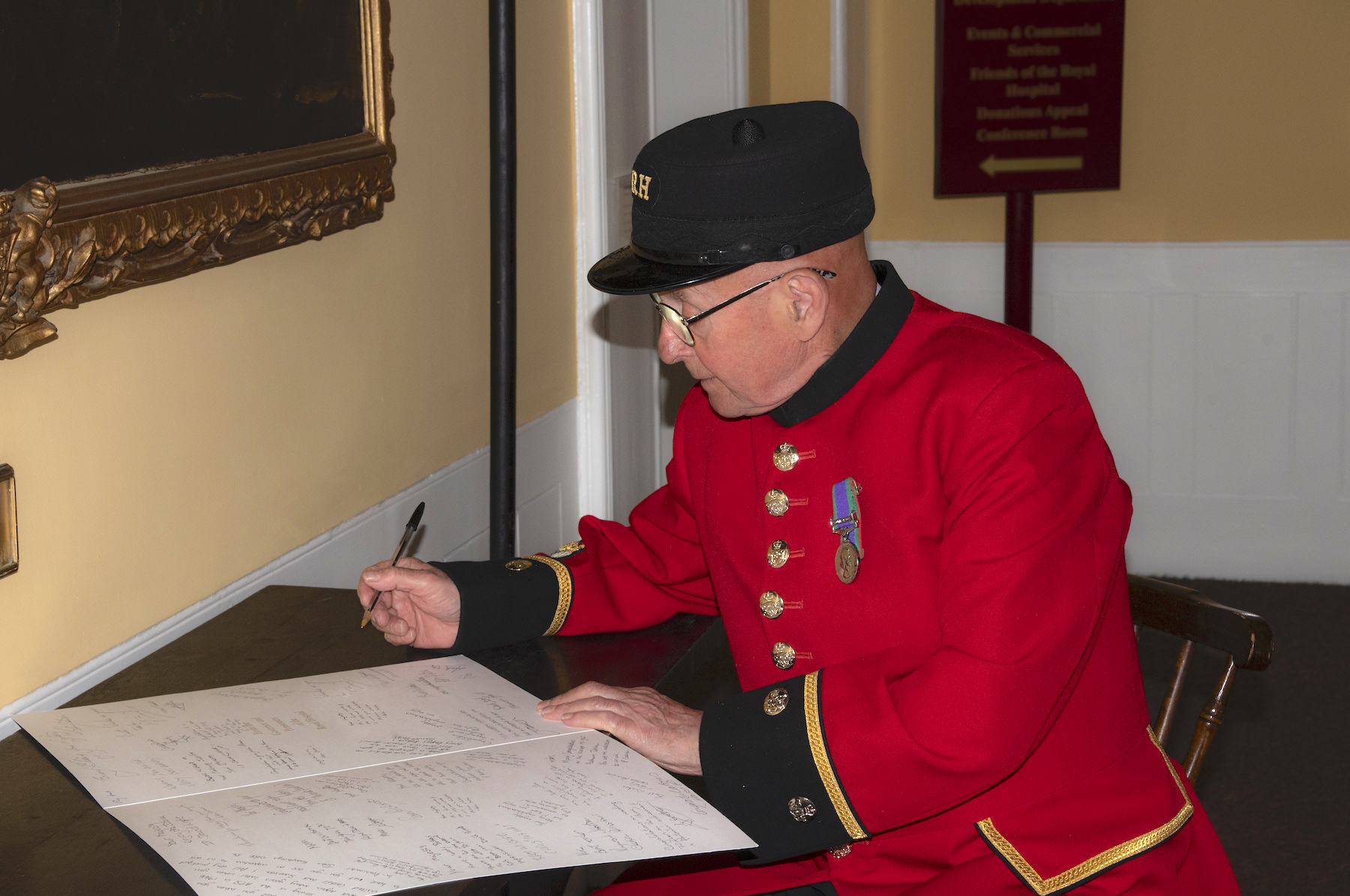 Jim Lycett signs the card for Her Majesty The Queen 