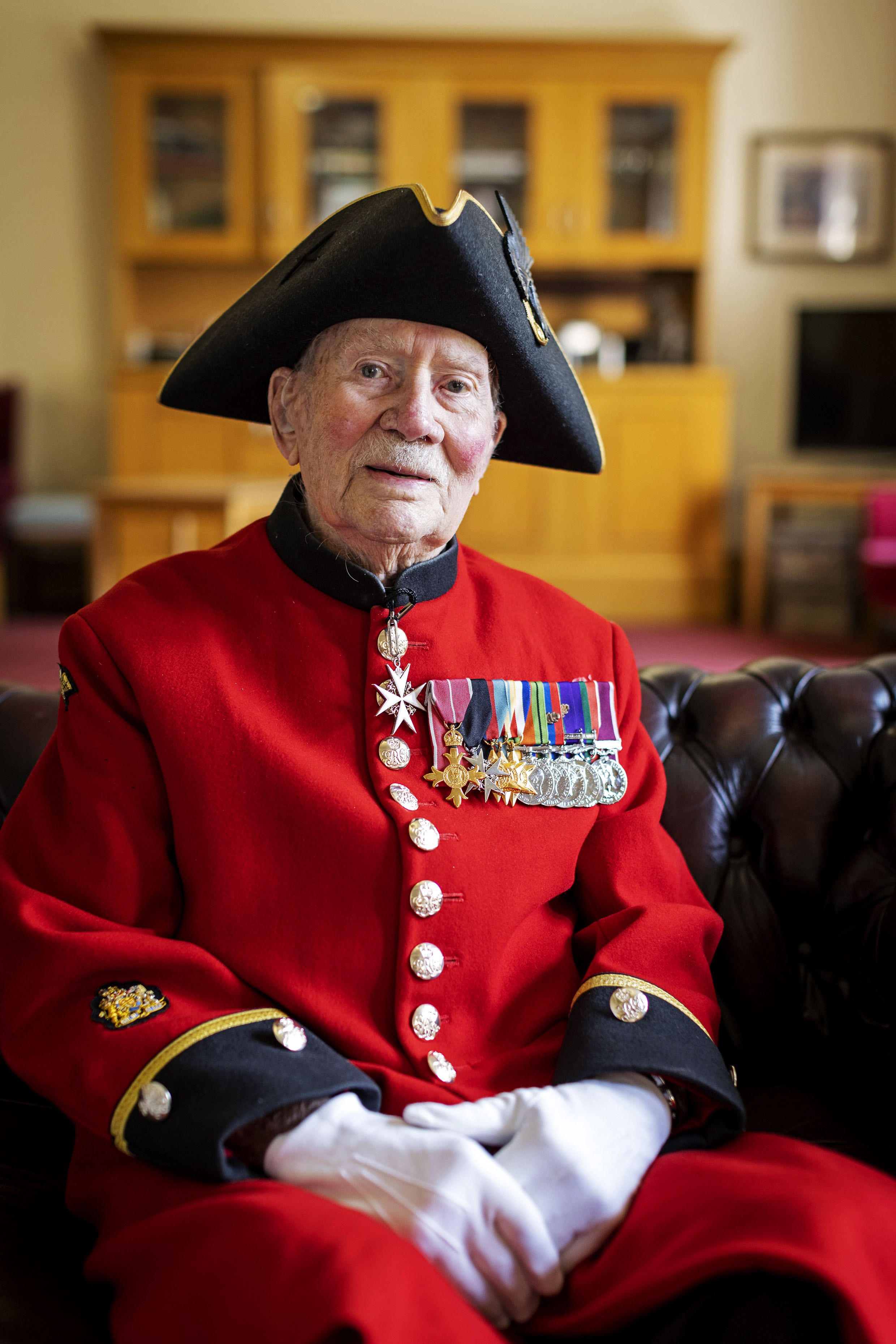 Chelsea Pensioner John Humphrey's sitting in scarlet uniform