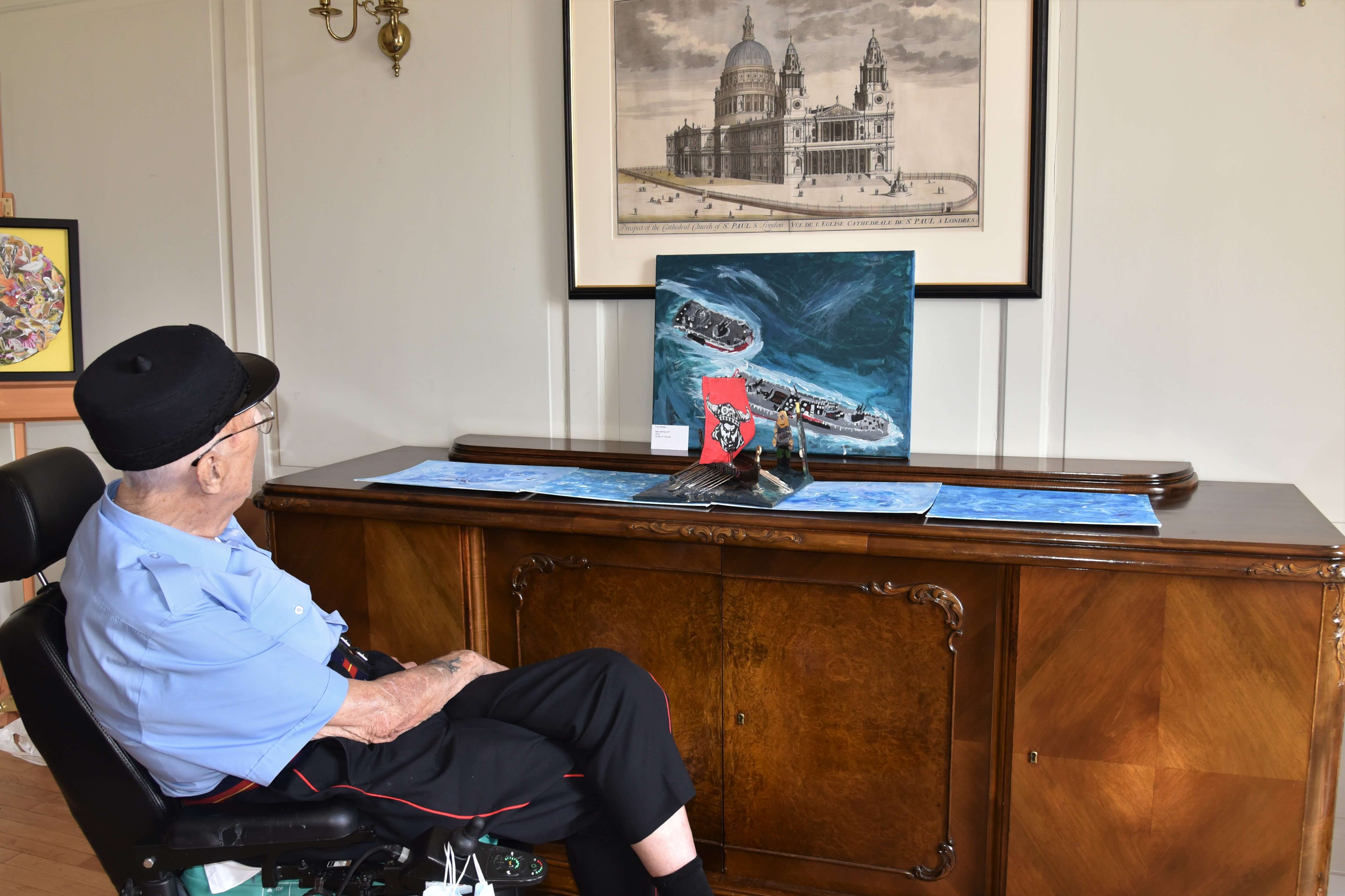 Tony Wadey made this wonderful model of a Viking longboat, displayed alongside his painting of battleships. (Ron Bicheno pictured viewing the artwork)