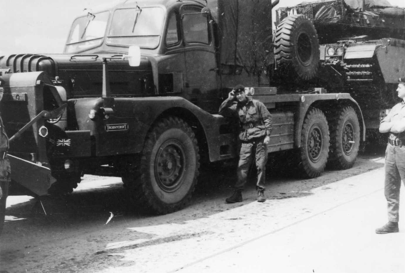 Soldier leaning on a car carrying centurion tank