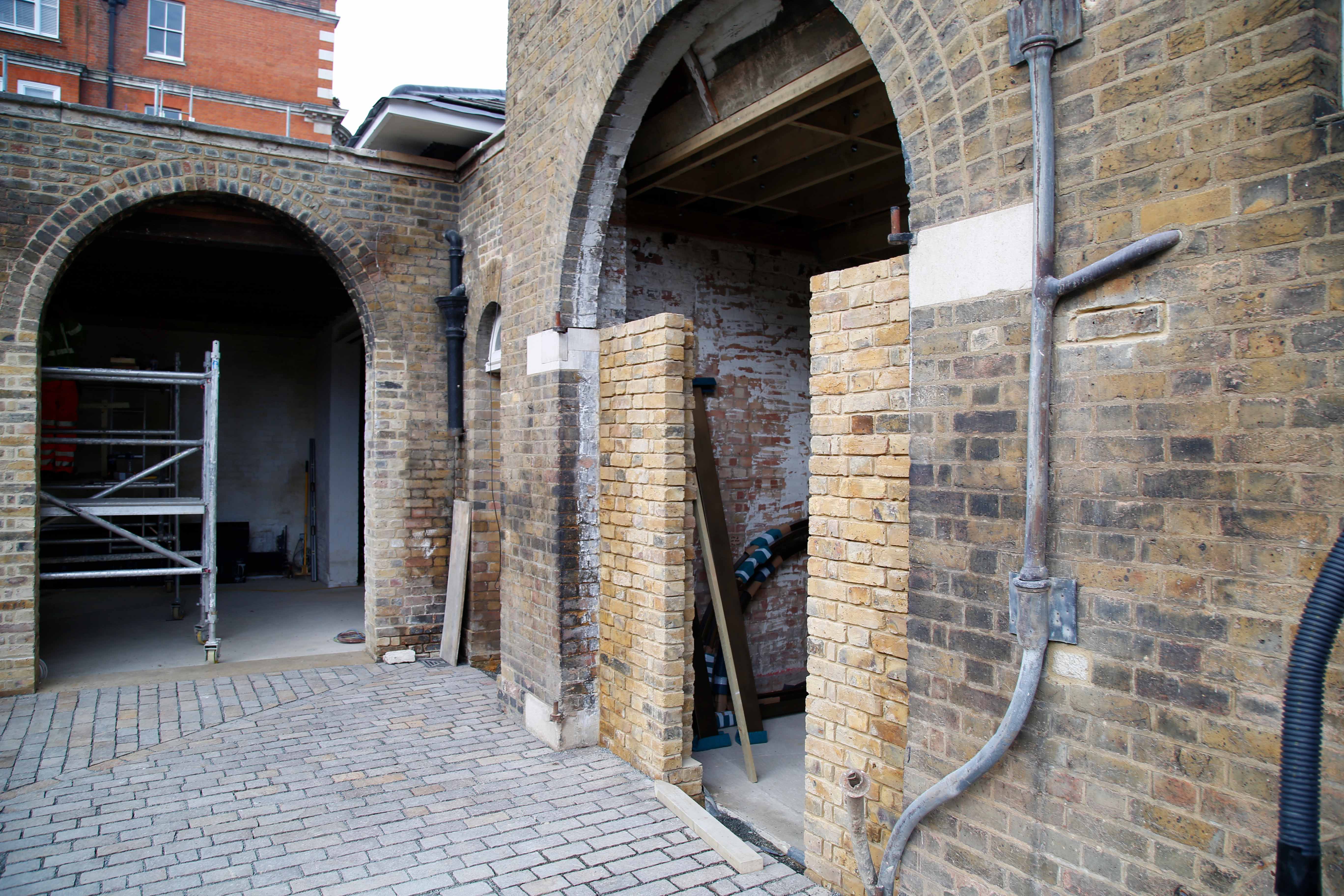 Brick wall of the Soane Stable building with open archway entrance