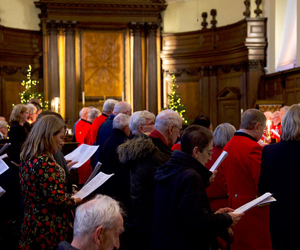 Group of people singing carols in a chapel