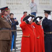 Chelsea Pensioners in scarlet uniforms saluting