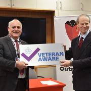 Prof Tim Briggs CBE (left) presents the Governor of the Royal Hospital (right) with the Veteran Aware plaque