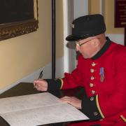 Jim Lycett signs Her Majesty The Queen's Card