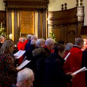 Group of people singing carols in a chapel